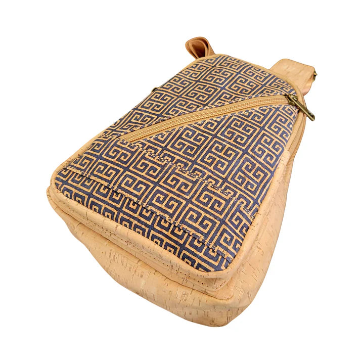 Bottom view  cork chest sling bag with navy Greek key pattern and slanted zipper pocket.